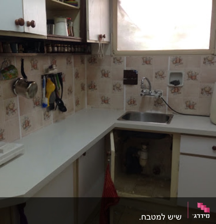 מטבח עם משטח שיש לבן ליד כיור